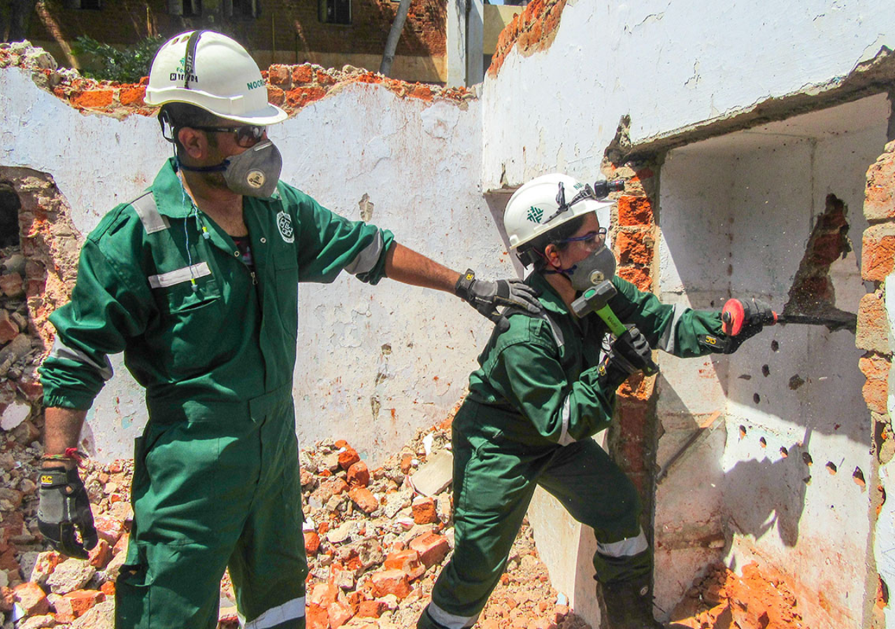 Man and woman trying to break a wall